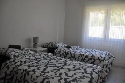 Un ou plusieurs lits dans un hébergement de l'établissement Appartement avec Jardin