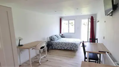 Un ou plusieurs lits dans un hébergement de l'établissement Le petit Château Avesnois - Studio avec terrasse vue sur le jardin