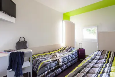 Un ou plusieurs lits dans un hébergement de l'établissement ENZO Hotels 1er PRIX
