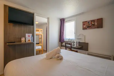 Un ou plusieurs lits dans un hébergement de l'établissement Brit Hotel Reims La Neuvillette