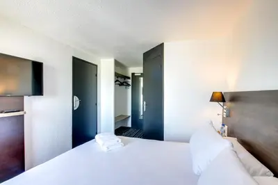 Un ou plusieurs lits dans un hébergement de l'établissement Brit Hotel Reims La Neuvillette