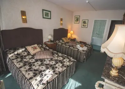 Un ou plusieurs lits dans un hébergement de l'établissement Hôtel De La Banniere De France