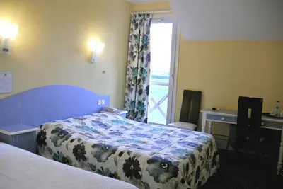 Un ou plusieurs lits dans un hébergement de l'établissement Logis Argonne Hôtel