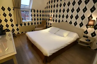 Un ou plusieurs lits dans un hébergement de l'établissement Cit'Hotel - Hotel Le Cèdre