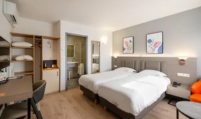 Un ou plusieurs lits dans un hébergement de l'établissement Hotel Tambourin