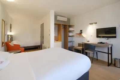 Un ou plusieurs lits dans un hébergement de l'établissement Hotel Tambourin