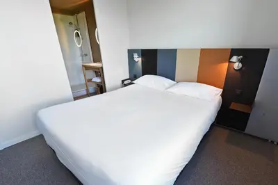 Un ou plusieurs lits dans un hébergement de l'établissement Cit'Hotel De Harlay