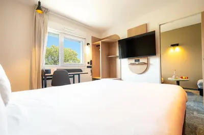 Un ou plusieurs lits dans un hébergement de l'établissement Hôtel Akena Reims Bezannes