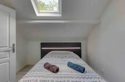 Un ou plusieurs lits dans un hébergement de l'établissement Maison avec jardin clos et privatif proche de Disneyland et parc des félins