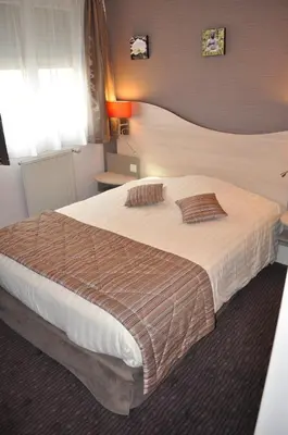 Un ou plusieurs lits dans un hébergement de l'établissement Logis Hôtel Au Tambour